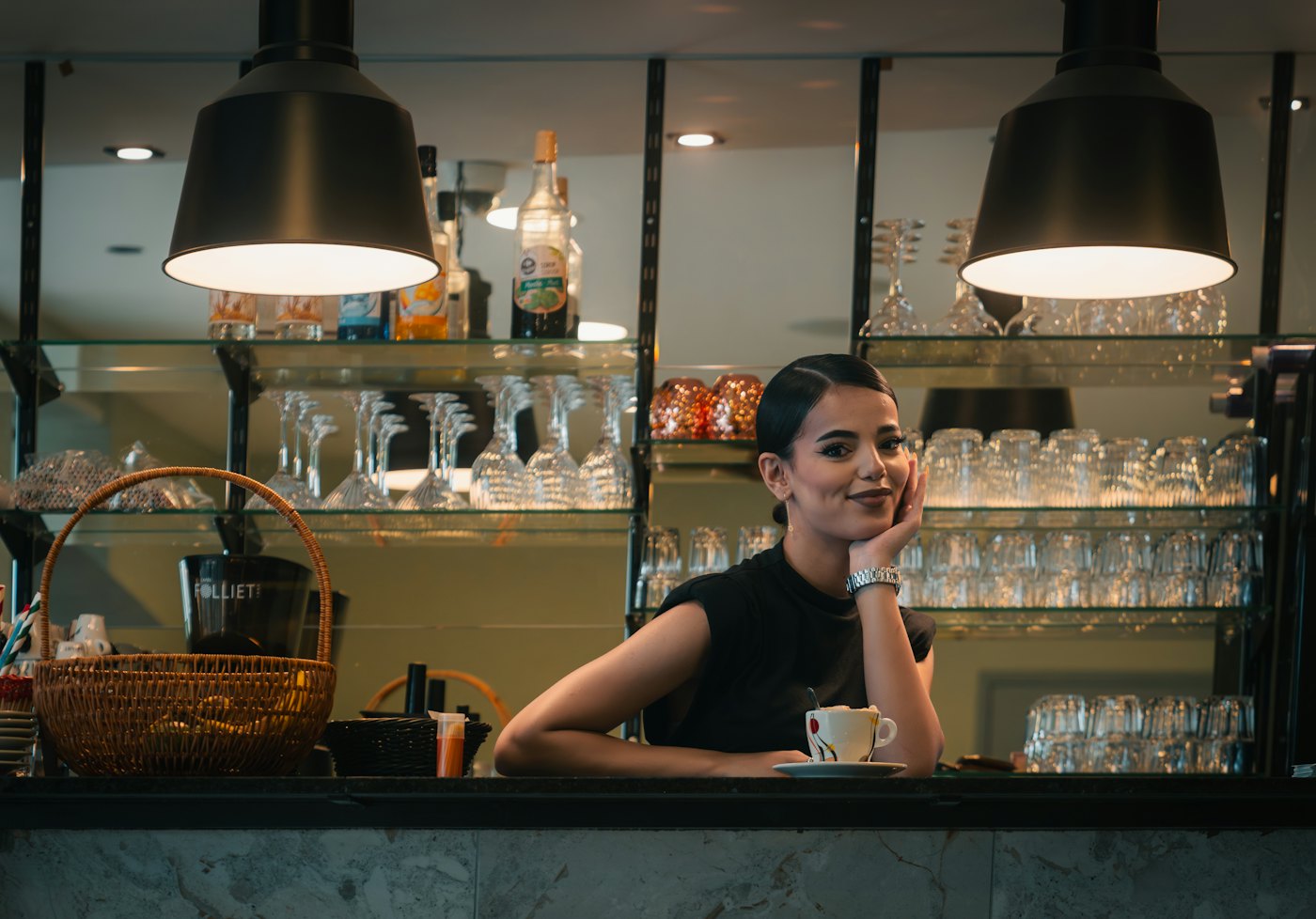 Una persona sonríe detrás de la barra de un restaurante